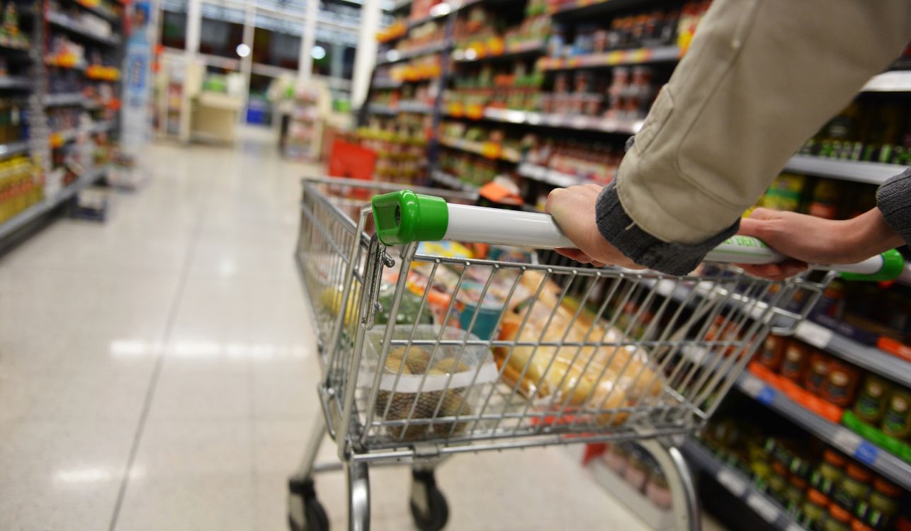 Person pushing trolley around a supermarket.