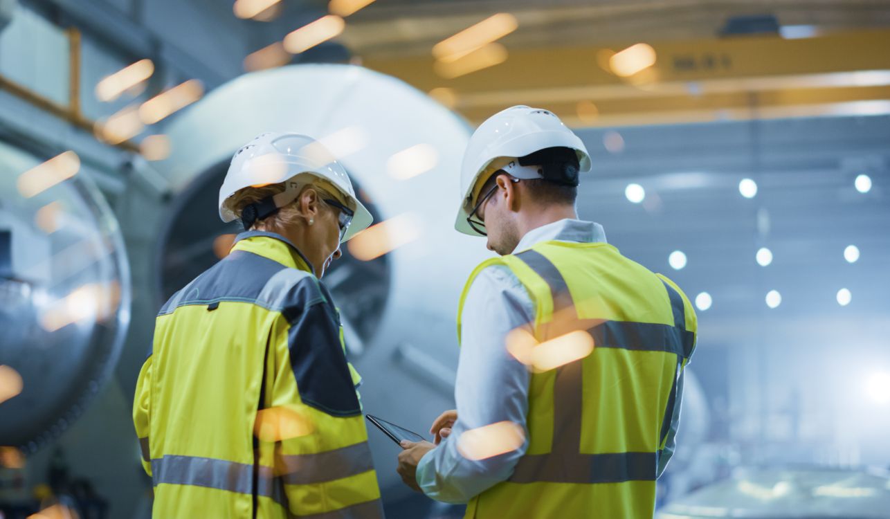 Image of manufacturing workers reading notes.